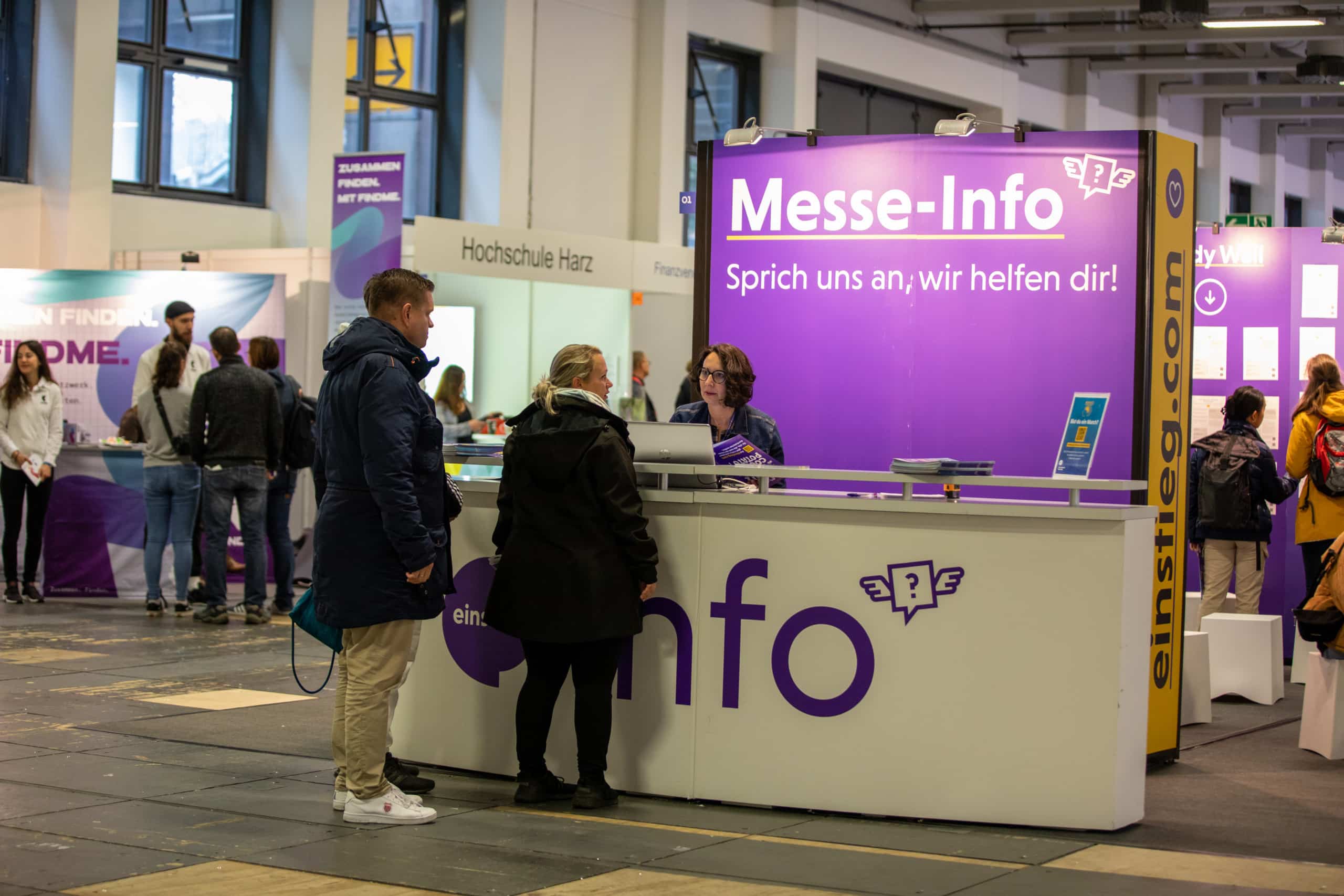 Besucher der Einstieg Berlin informieren sich an der Einstieg Messe-Info